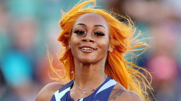 Sha'Carri Richardson with orange hair blowing in the wind